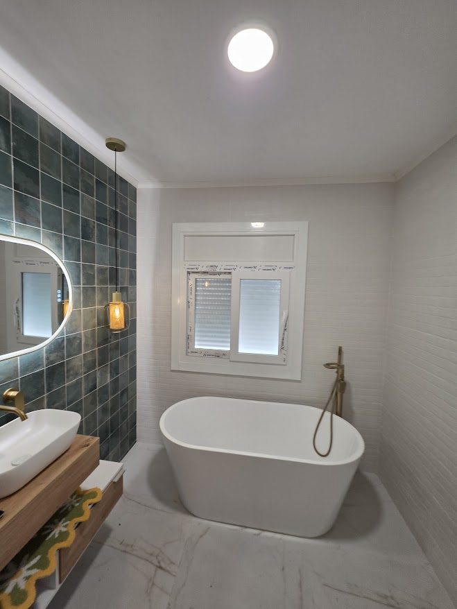 Baño con bañera exenta y grifería dorada