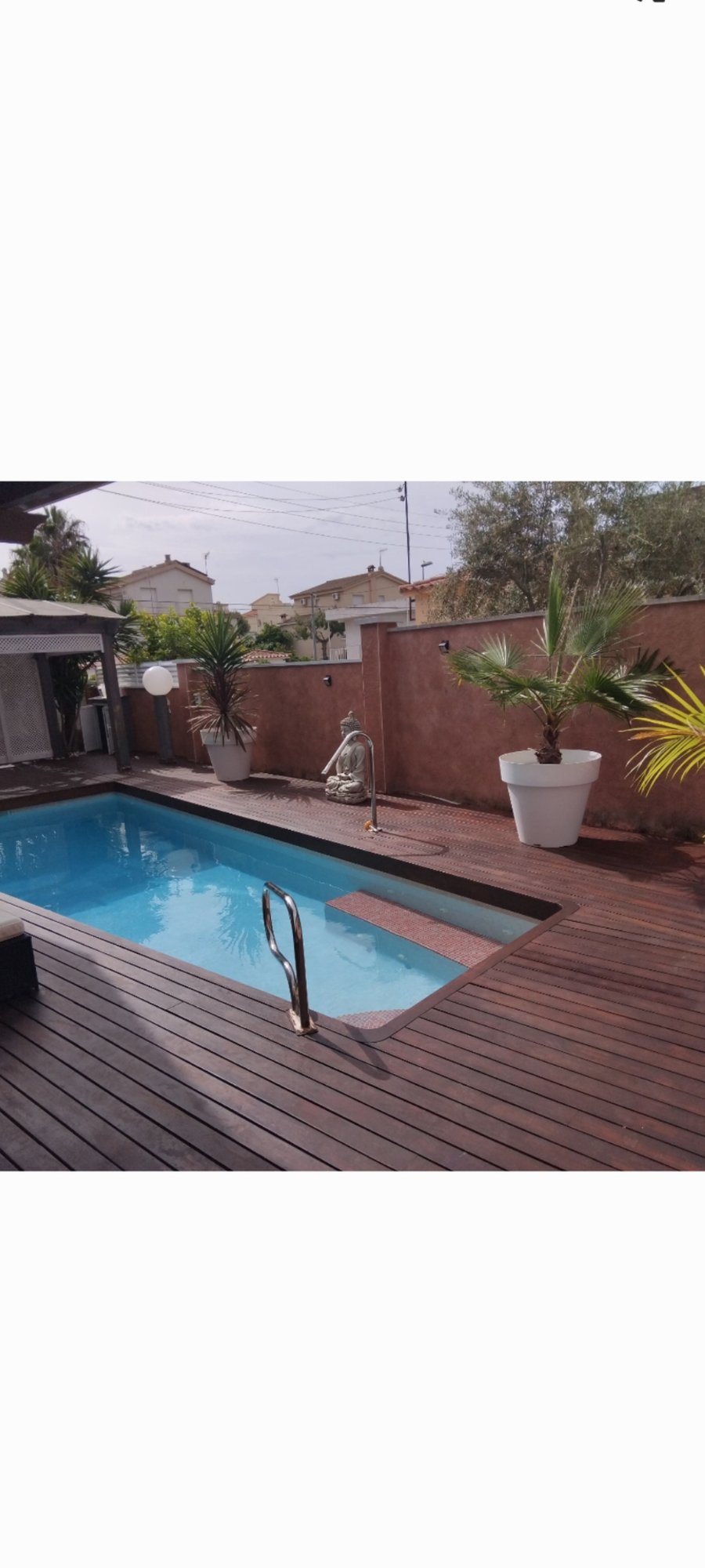 Jardín con piscina y terraza de madera